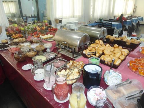 a table with a buffet of food on it at Hotel London in Araraquara