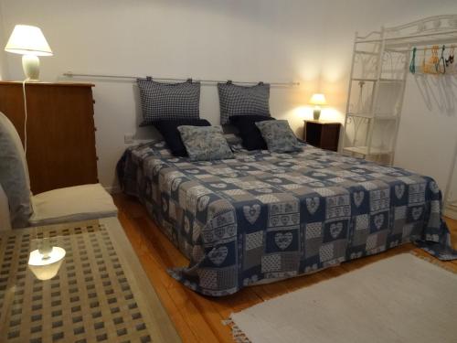 a bedroom with a bed with a blue and white blanket at Maison Majorelle in Moussoulens