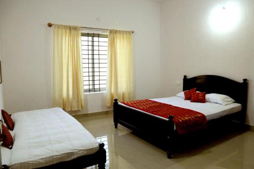 a bedroom with two beds and a window at Coffee Native - A Family Homestay in Mudigere