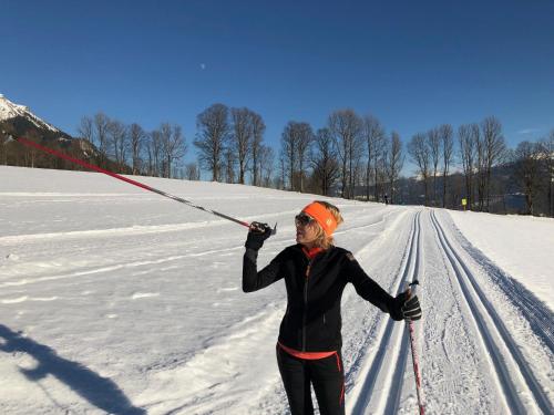 a woman on skis in the snow holding two poles at Appartement Aich-Assach in Aich