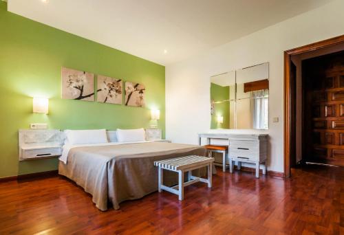 a bedroom with a large bed and a desk at Hotel Los Olivos in Getafe