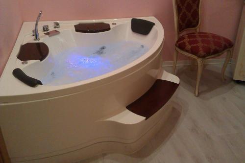 a bath tub with a sink and a chair at Garda Sol SPA Hotel & Appartamenti in Toscolano Maderno