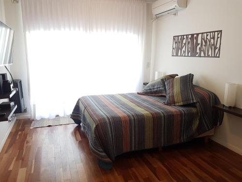 a bedroom with a bed and a large window at Rincón Rosarino in Rosario