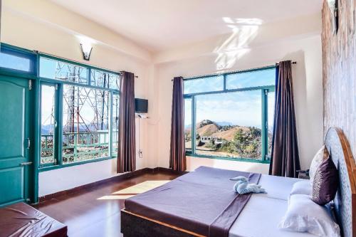 a bedroom with a bed and a large window at Trimurti Pine Valley Resort in Shimla