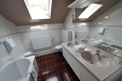 a bathroom with two sinks and a toilet at Hotel Le Charme de la Semois in Alle