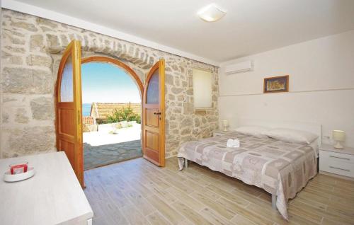 1 dormitorio con 1 cama y puerta abierta en Villa Ursula, en Podgora