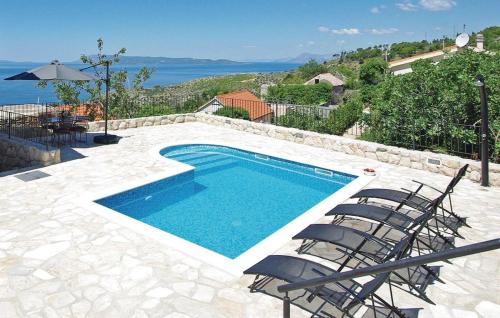 a swimming pool with chairs and a view of the ocean at Villa Ursula in Podgora