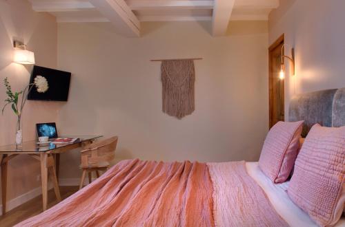 a bedroom with a bed and a table and a desk at Hôtel Le Pré Saint Michel in Manosque