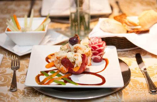 a plate of food with shrimp and vegetables on a table at Summit Hotel Monaco in Guarulhos