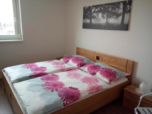 ウィーンにあるNordrand-Apartmentのベッドルーム1室(ピンクと紫の枕が付いたベッド1台付)