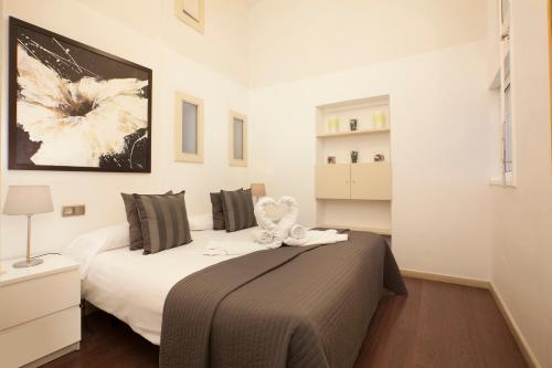a bedroom with a large bed with a brown blanket at Rent Top Apartments near Plaza de Catalunya in Barcelona