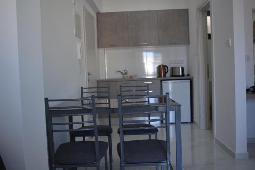 a kitchen with chairs and a table and a counter at P.L Hermes Studios & Apartments in Larnaka