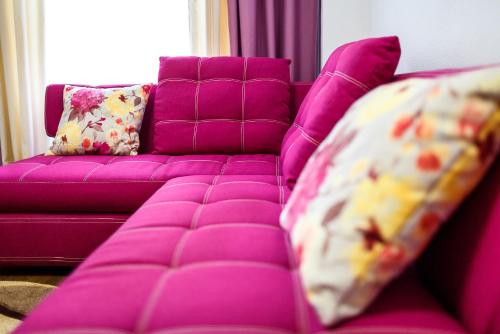 a purple couch with pillows next to a purple couch at Discovery Hotel in Lviv