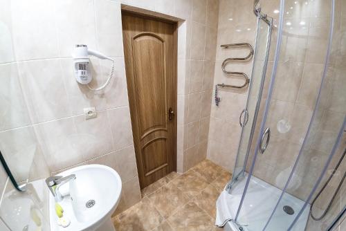 a bathroom with a shower and a toilet and a sink at Discovery Hotel in Lviv