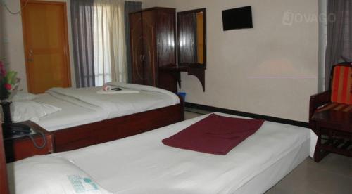 科克斯巴扎爾的住宿－奧斯特愛卡酒店，一间带两张床和梳妆台的卧室