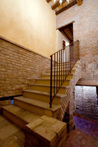 a staircase in a building with a brick wall at Hospitale I Mori in Asola
