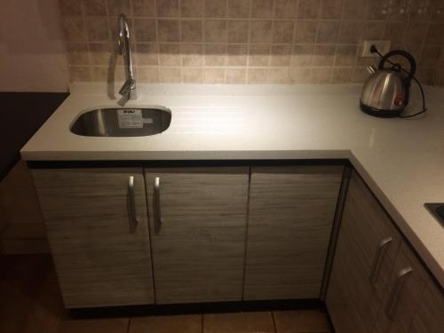 una cucina con un lavello e un piano di lavoro di Bahía Pelícanos a Horcón