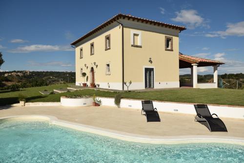 a villa with a swimming pool in front of a house at Tenuta Donna Caterina in Tessennano