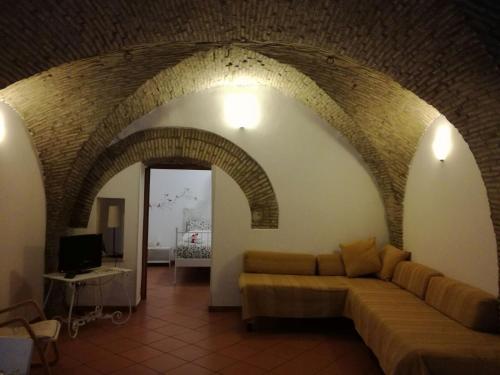 sala de estar con sofá y arco en Svegliarsi nei Borghi - La Patronale, en Troia