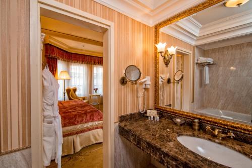 a bathroom with a sink and a bed and a mirror at Nobilis Hotel in Lviv