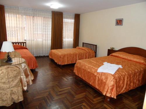 トルヒーリョにあるHostal Bona Nitのベッド2台とテーブルが備わるホテルルームです。