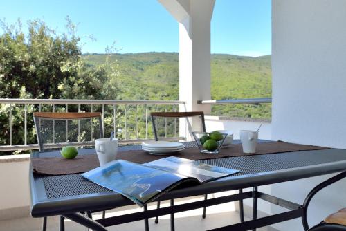 a table with a book on top of a balcony at Apartment Andrea in Sveta Marina