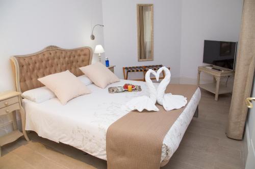 a bedroom with a bed with two swans on it at Oriente Palace Apartments in Madrid