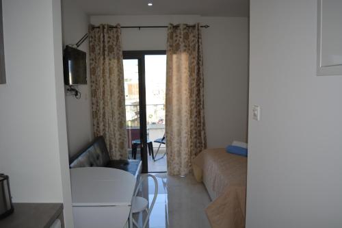a room with a bed and a table and a couch at P.L Hermes Studios & Apartments in Larnaka
