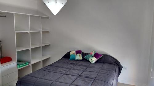 a bedroom with a bed with two pillows on it at Condominio del Faro - Quequen in Necochea