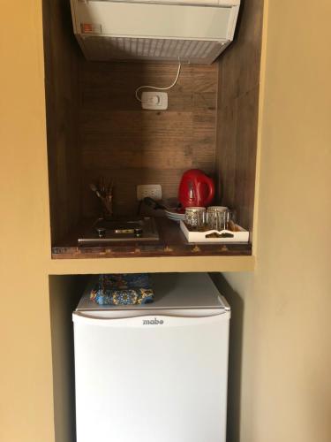 a small refrigerator in a kitchen with a counter at El Viento De Mi Sueño in Tafí del Valle