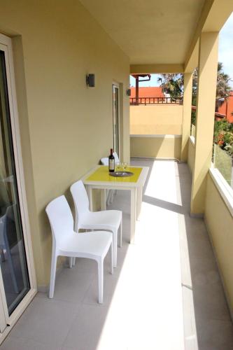 a balcony with a table and two white chairs at Effi Apartments in Plataniás