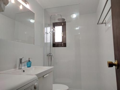 a bathroom with a sink and a toilet and a mirror at Acogedor apartamento en el casco histórico in Toledo