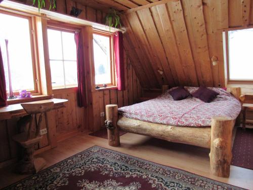 a bedroom with a bed in a wooden cabin at Metsatu Valge Elevandi puhkemaja in Otepää