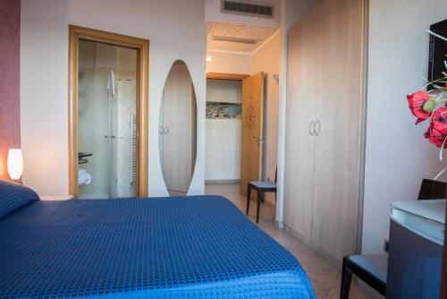 a bedroom with a blue bed and two surfboards at Hotel Mirage in Torre Santa Sabina