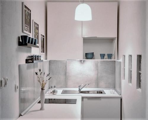 a kitchen with a sink and a vase of flowers at Vlatkovićeva Apartments in Senj