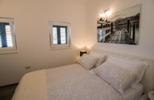 a bedroom with a bed and a picture on the wall at Incantesimo luxury penthouse in Mimice