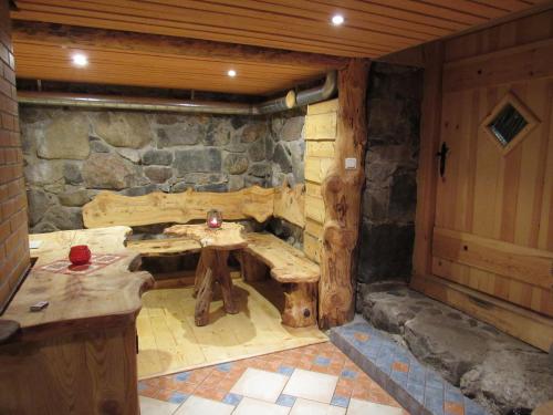a room with a stone wall with a wooden table at Metsatu Valge Elevandi puhkemaja in Otepää