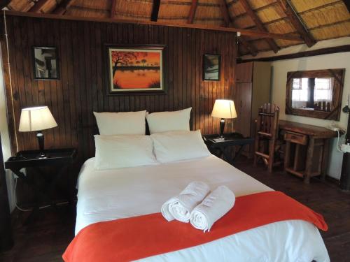 a bedroom with a large bed with two towels on it at Karibu River Retreat in Marble Hall