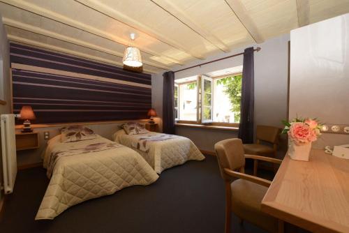 A bed or beds in a room at Logis Hôtel Restaurant & Spa les Remparts