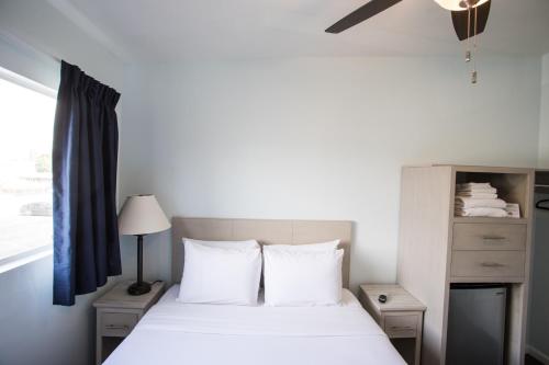 a bedroom with a bed with white sheets and a window at Ocean Park Hotel in Los Angeles