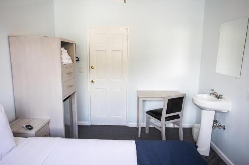 a bedroom with a bed and a desk and a sink at Ocean Park Hotel in Los Angeles