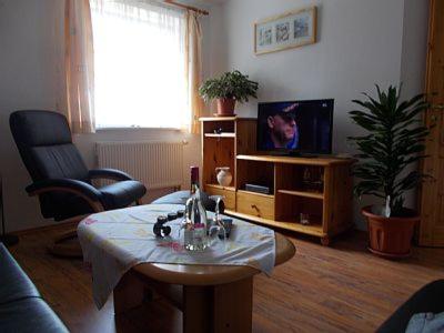 uma sala de estar com uma mesa e uma televisão em Ferienwohnung Hauke em Tönning