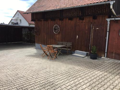 a patio with a table and chairs in front of a building at Ferienwohnung Rauch in Pretzfeld