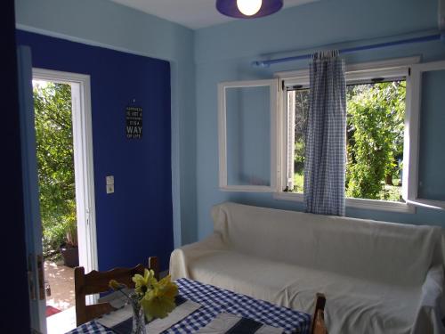 a living room with a white couch and two windows at Ellenas- studios in Nikiana