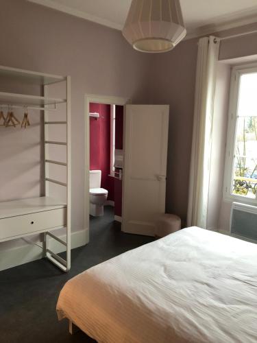 a bedroom with a white bed and a bathroom at Lamarck Guest in Bourges
