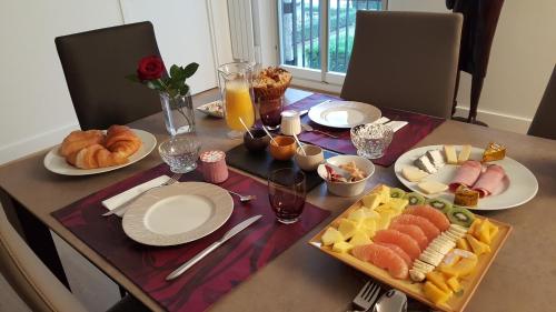a table with food and plates of food on it at Assia & Nathalie - Luxury B&B MARAIS in Paris