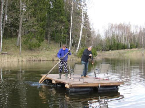 two people are standing on a dock in the water at Metsatu Valge Elevandi puhkemaja in Otepää