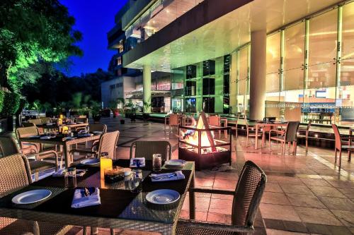 a restaurant with tables and chairs in front of a building at The Lalit Chandigarh in Chandīgarh