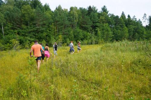 a group of people walking through a field at Prūsiškių dvaras in Sumiliszki