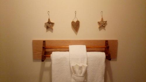 um toalheiro com toalhas e corações na parede em Auberge Micro-Brasserie Le Baril Roulant em Val-David